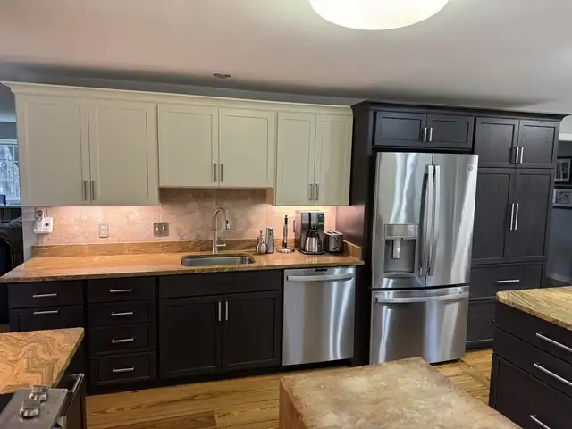 Kitchen with white upper cabinets, espresso lower cabinets and a tall pantry beside a stainless refrigerator