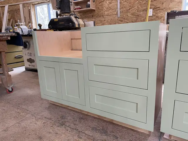 Sage green shaker cabinet with drawers being built in the Laplante Cabinetry shop